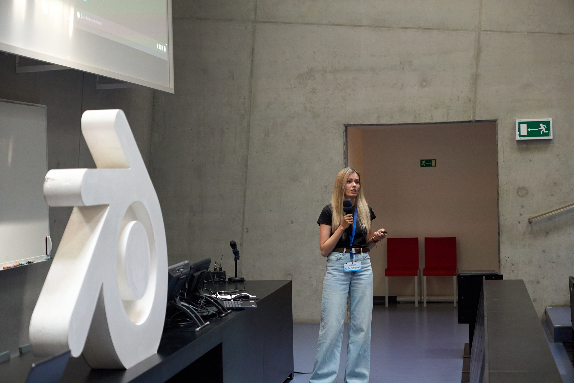 Petra na konferenci s mikrofonem v přednáškovém sále